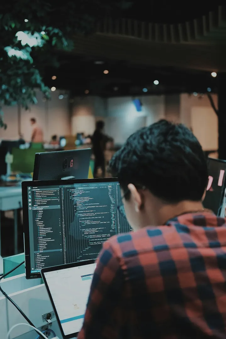 Software engineer working with code on a desktop monitor
