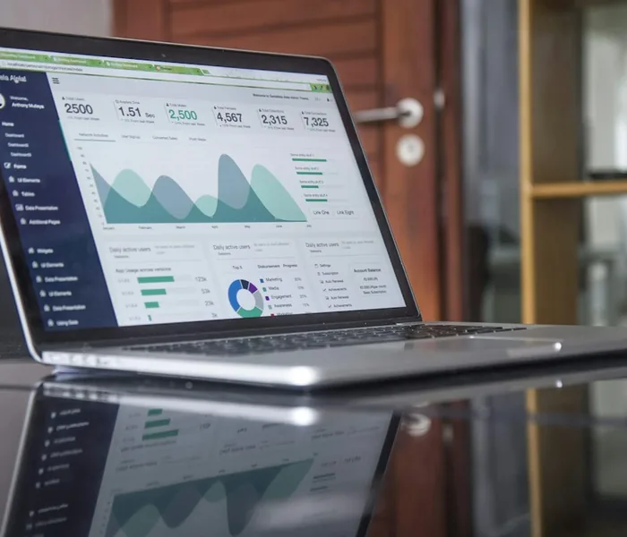 Laptop displaying statistics on a glass table