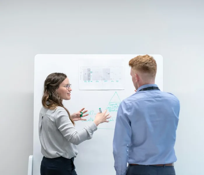 Engineers discussing technical work at a whiteboard